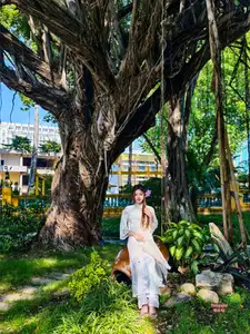 Graceful Ao Dai: Explore the Timeless Traditional Beauty of a Vietnamese Girl with an Elegant Parasol in a Lush Garden Setting - image 2