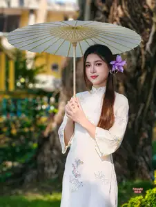 Graceful Ao Dai: Explore the Timeless Traditional Beauty of a Vietnamese Girl with an Elegant Parasol in a Lush Garden Setting - image 6