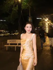 Elegant Young Woman in Golden Silk Dress Shines in Modern Urban Setting. Captivating Style. Code: 1000026984 - image 1