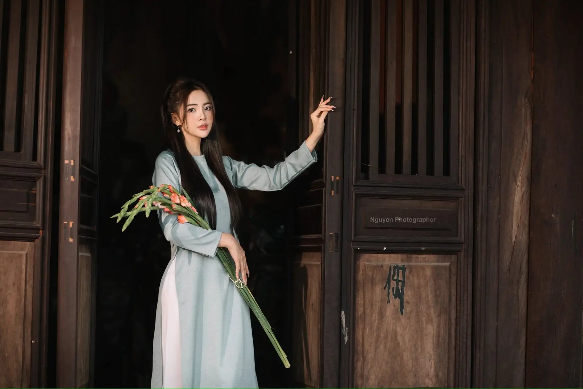 Elegant Ao Dai Beauty: Vietnamese Girl's Grace with Flowers in a Classic Setting