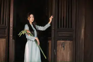 Elegant Ao Dai Beauty: Vietnamese Girl's Grace with Flowers in a Classic Setting - image 0