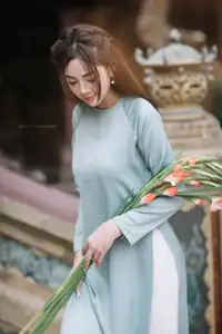 Elegant Ao Dai Beauty: Vietnamese Girl's Grace with Flowers in a Classic Setting - image 2