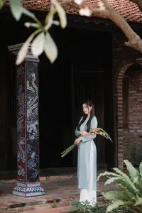Elegant Ao Dai Beauty: Vietnamese Girl's Grace with Flowers in a Classic Setting - image 1