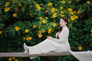 Radiant Youth: Vietnamese Girl in Elegant White Ao Dai Amidst Golden Blooms - image 18