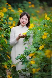 Radiant Youth: Vietnamese Girl in Elegant White Ao Dai Amidst Golden Blooms - image 2