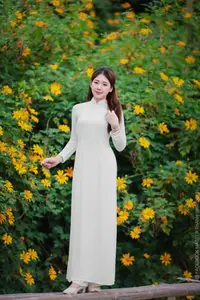 Radiant Youth: Vietnamese Girl in Elegant White Ao Dai Amidst Golden Blooms - image 0