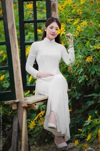 Radiant Youth: Vietnamese Girl in Elegant White Ao Dai Amidst Golden Blooms - image 3
