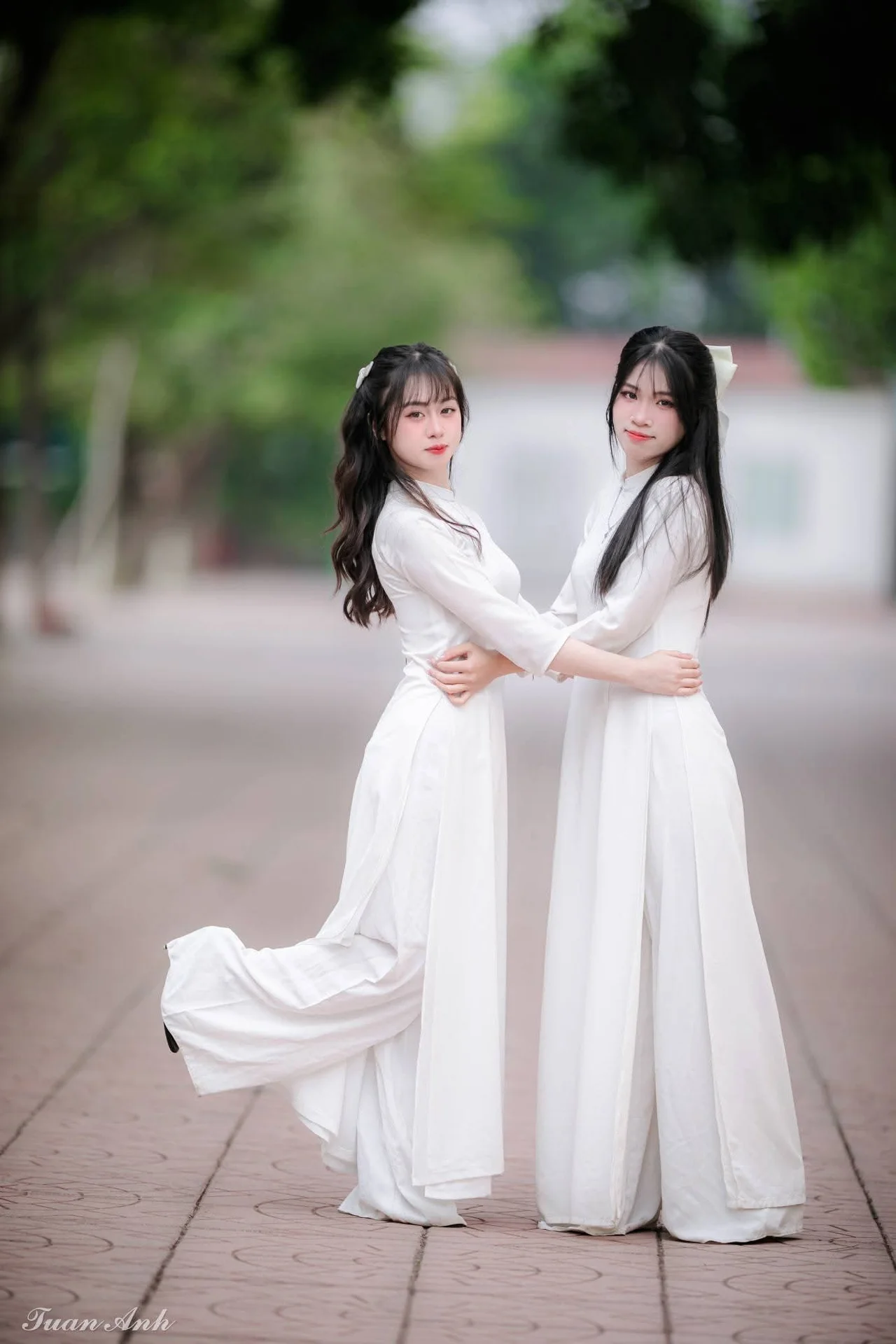 Graceful Vietnamese Girl in Elegant White Ao Dai with Sweet Finger Heart Gesture