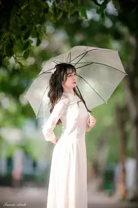 Graceful Vietnamese Girl in Elegant White Ao Dai with Sweet Finger Heart Gesture - image 2
