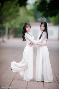 Graceful Vietnamese Girl in Elegant White Ao Dai with Sweet Finger Heart Gesture - image 0