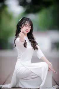 Graceful Vietnamese Girl in Elegant White Ao Dai with Sweet Finger Heart Gesture - image 8