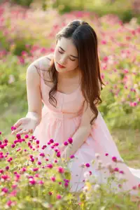 Serene Beauty: Young Woman in Pink Dress Amidst a Vibrant Flower Field - image 0