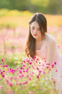 Serene Beauty: Young Woman in Pink Dress Amidst a Vibrant Flower Field - image 1