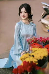 Traditional Vietnamese Beauty: Graceful Girl in Blue Ao Dai with Fresh Flowers - image 13