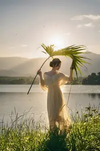 Golden Hour Serenity: Woman in White Dress Embracing Nature's Beauty by the Lake at Sunset. - image 3