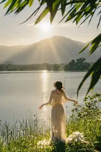 Golden Hour Serenity: Woman in White Dress Embracing Nature's Beauty by the Lake at Sunset. - image 10