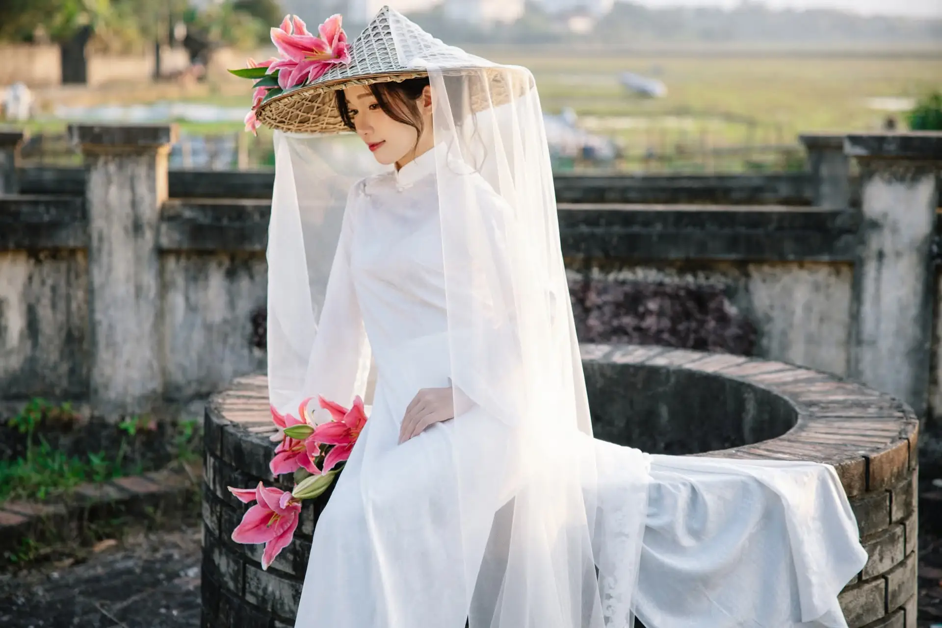 Discover the captivating grace of a Vietnamese woman in a flowing white Ao Dai and traditional conical hat