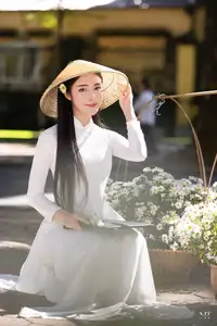 Vietnamese Ao Dai Beauty: Graceful girl with white daisies, an enchanting blend of tradition and charm. - image 0