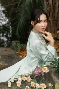 Graceful Vietnamese Woman in Light Green Ao Dai Amidst Tranquil Garden - image 3