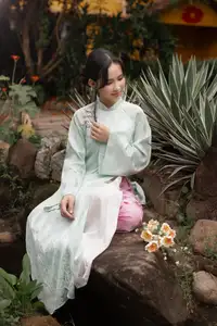 Graceful Vietnamese Woman in Light Green Ao Dai Amidst Tranquil Garden - image 6