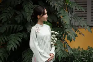 Graceful Vietnamese Woman in Light Green Ao Dai Amidst Tranquil Garden - image 0