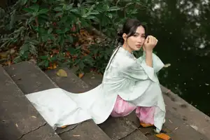 Graceful Vietnamese Woman in Light Green Ao Dai Amidst Tranquil Garden - image 4