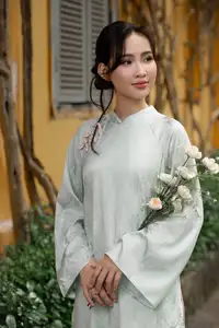 Graceful Vietnamese Woman in Light Green Ao Dai Amidst Tranquil Garden - image 1