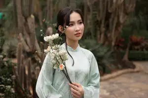 Graceful Vietnamese Woman in Light Green Ao Dai Amidst Tranquil Garden - image 2