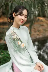 Graceful Vietnamese Woman in Light Green Ao Dai Amidst Tranquil Garden - image 5