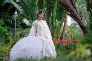 Vietnamese Beauty: Elegant Girl in White Ao Dai, Conical Hat with Yellow Flowers in Ancient Garden - image 1