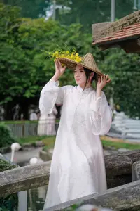 Vietnamese Beauty: Elegant Girl in White Ao Dai, Conical Hat with Yellow Flowers in Ancient Garden - image 0