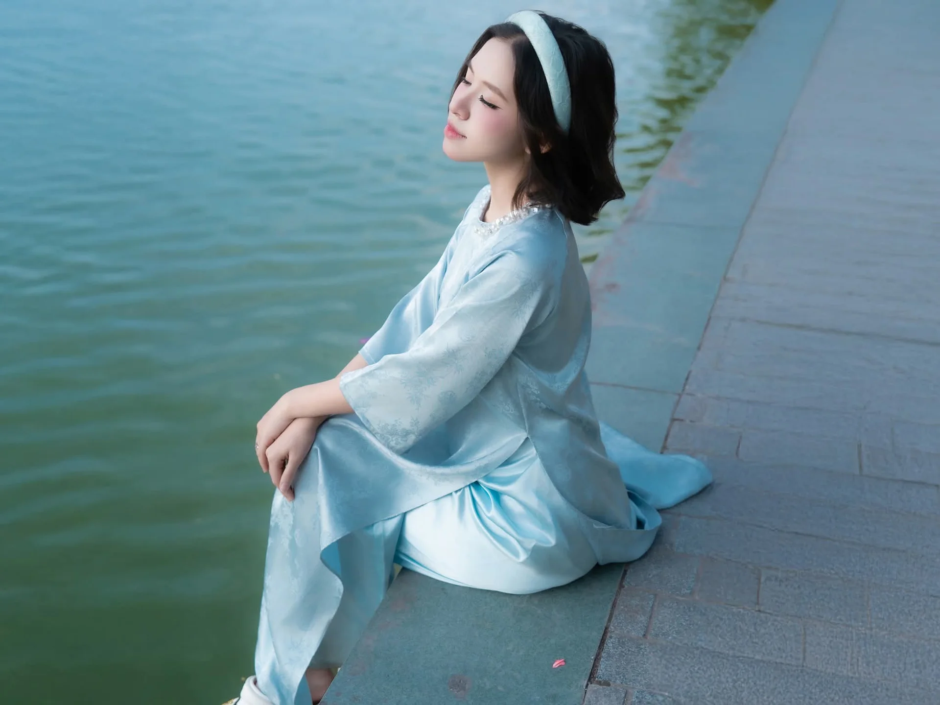 Serene Beauty: Vietnamese Young Woman by the Lake in Traditional Attire