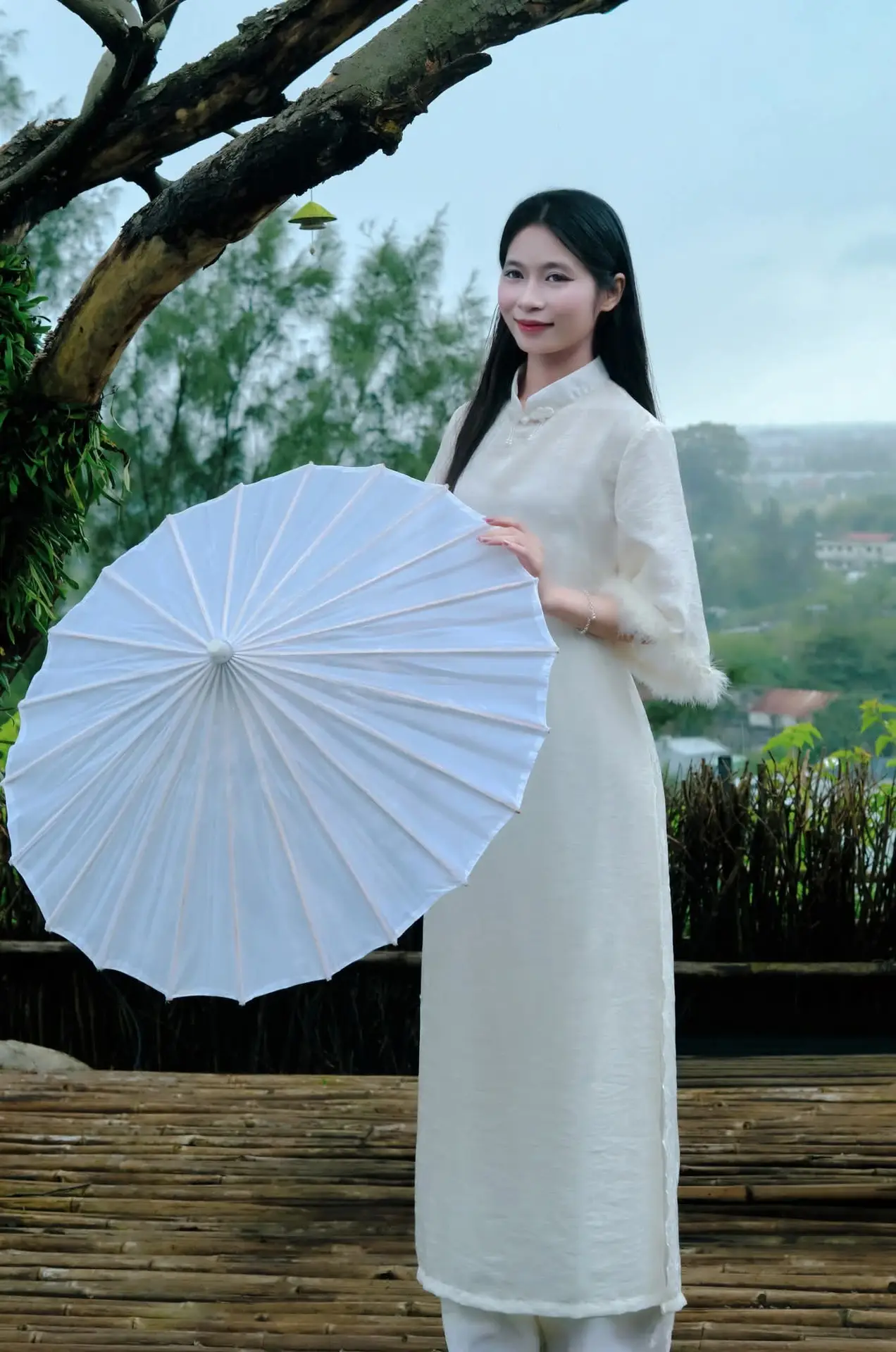 Graceful Vietnamese Woman in White Ao Dai with Lotus Flower in Serene Garden