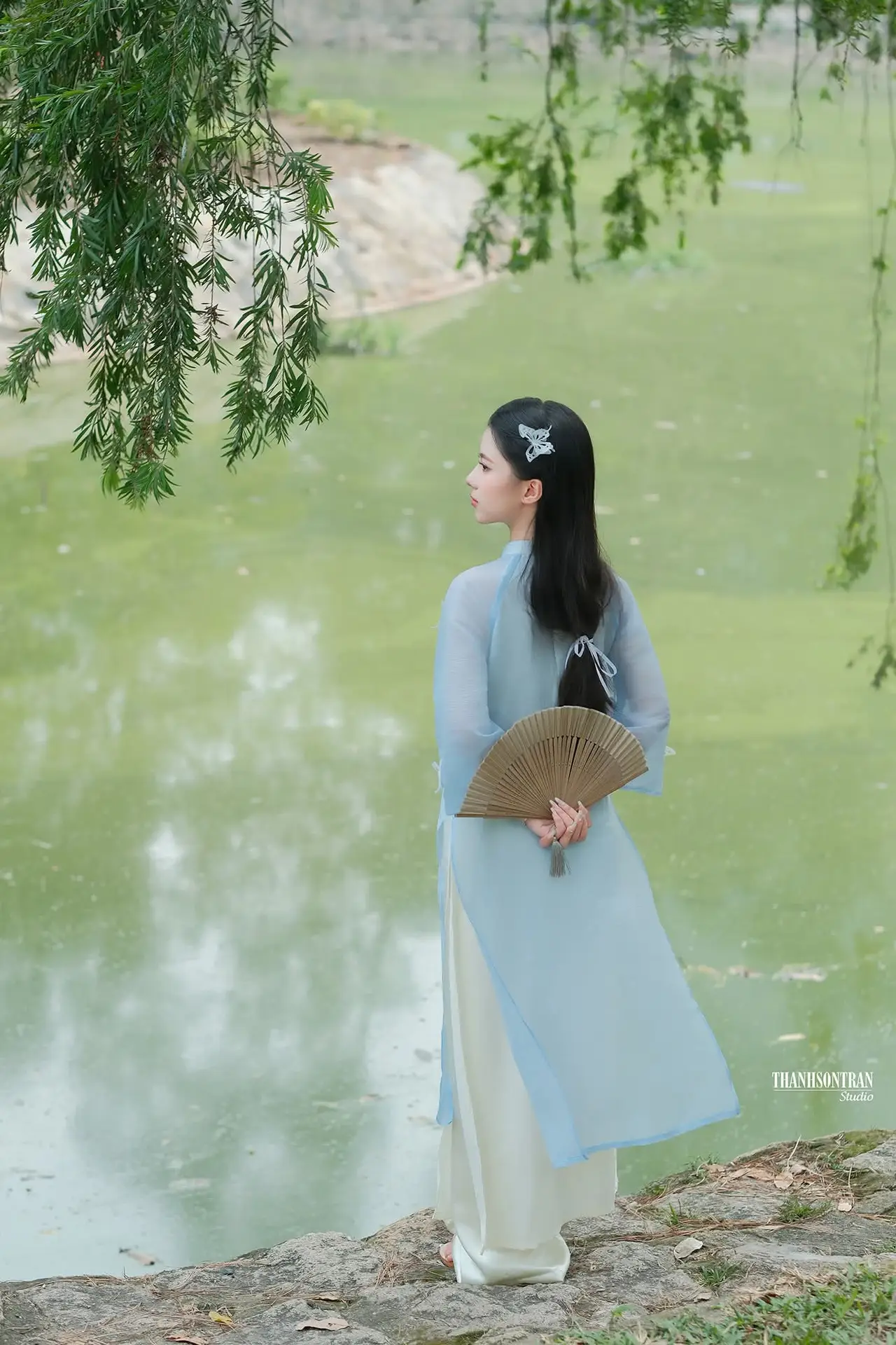 Elegant Vietnamese Maiden in Áo Dài Amidst Serene Nature's Embrace