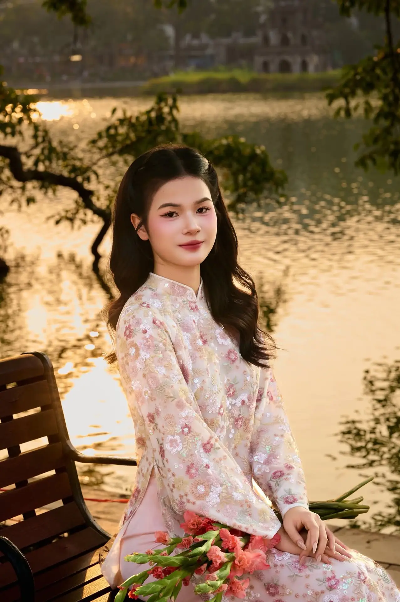 Vietnamese Ao Dai Beauty by the Lake at Sunset: Graceful Girl with Vibrant Gladiolus Flowers.