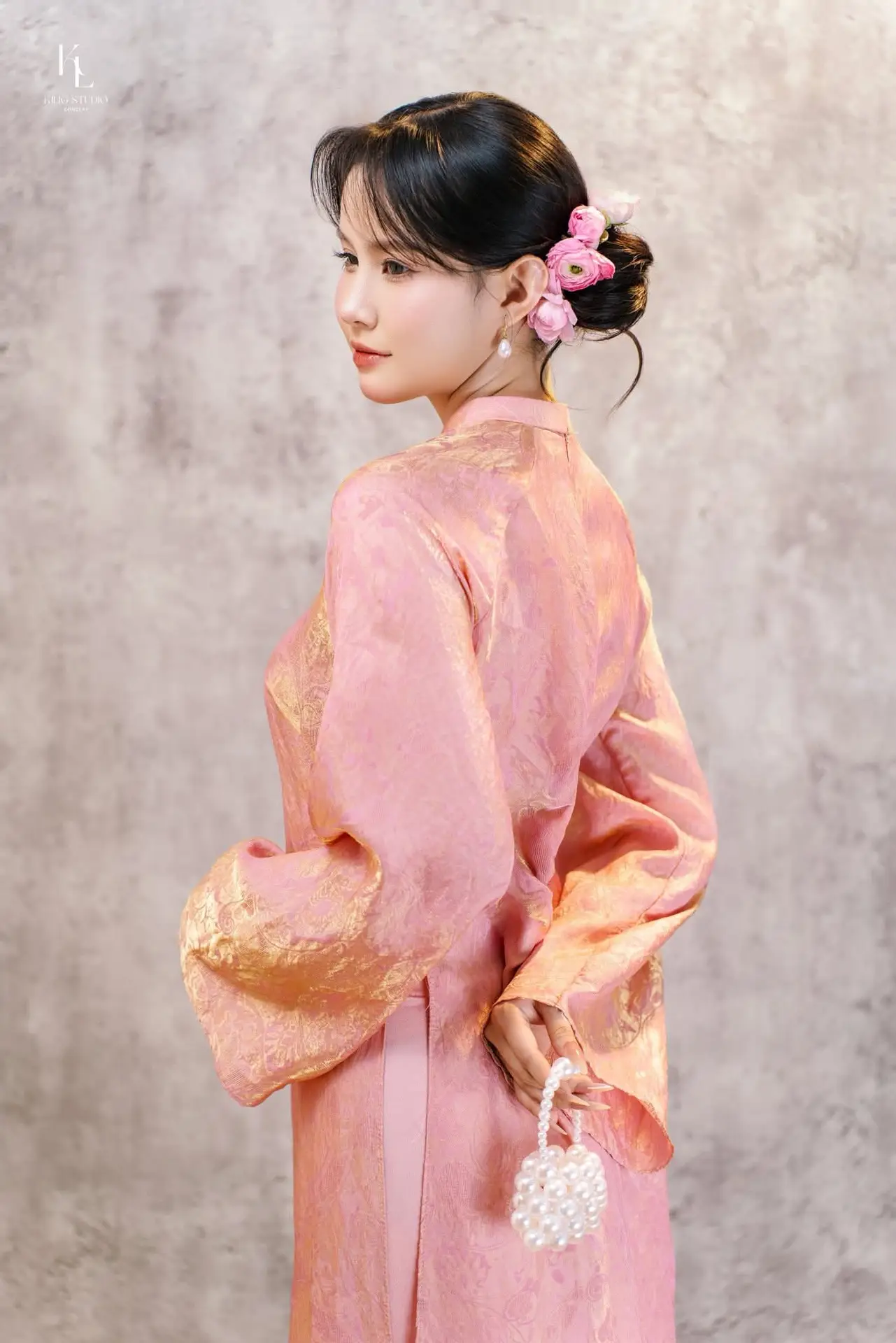 Elegant Asian Charm: Serene Young Woman in Traditional Pink Attire with Delicate Fresh Flowers