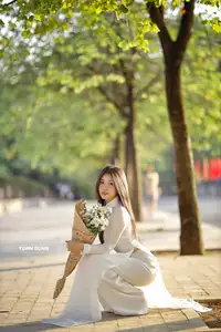 Captivating Beauty: Vietnamese Girl in White Ao Dai with Delicate Daisies. - image 1