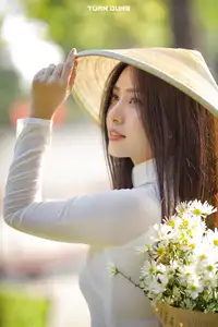 Captivating Beauty: Vietnamese Girl in White Ao Dai with Delicate Daisies. - image 11