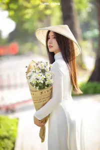 Captivating Beauty: Vietnamese Girl in White Ao Dai with Delicate Daisies. - image 6