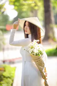 Captivating Beauty: Vietnamese Girl in White Ao Dai with Delicate Daisies. - image 7