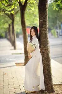 Captivating Beauty: Vietnamese Girl in White Ao Dai with Delicate Daisies. - image 4