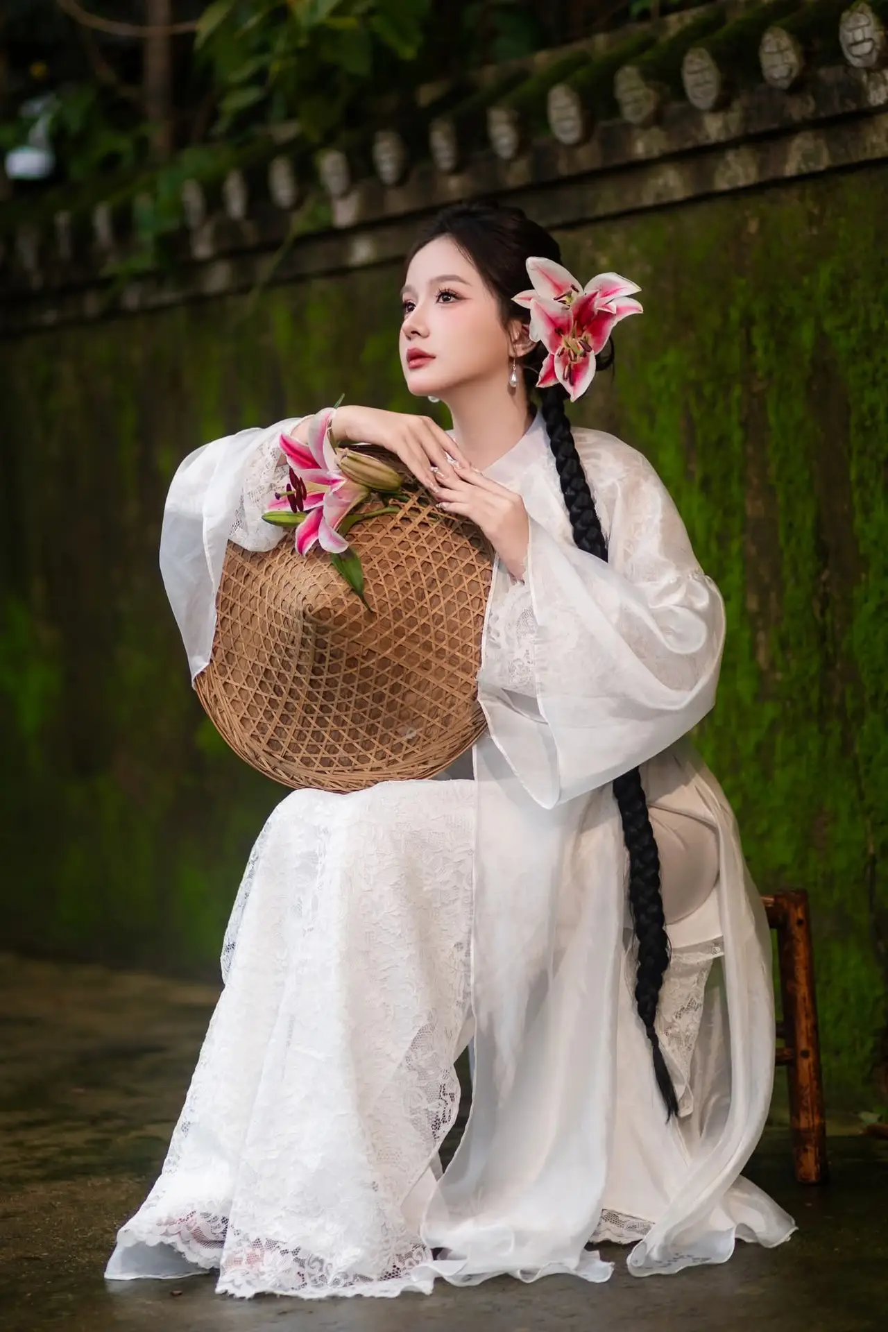 Captivating Asian Beauty: Discover the Ethereal Charm of a Maiden in White with a Blossom in Her Hair.