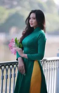 Vietnamese Grace: Elegant Woman in Green Ao Dai with Pink Lotus Flower 1000025232 - image 0