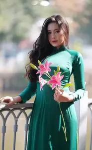 Vietnamese Grace: Elegant Woman in Green Ao Dai with Pink Lotus Flower 1000025232 - image 7