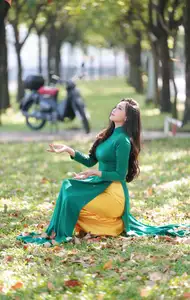 Vietnamese Grace: Elegant Woman in Green Ao Dai with Pink Lotus Flower 1000025232 - image 2