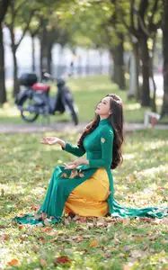 Vietnamese Grace: Elegant Woman in Green Ao Dai with Pink Lotus Flower 1000025232 - image 3