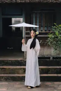 Discover the Grace of a Vietnamese Woman in White Ao Dai with Elegant Lilies - image 4