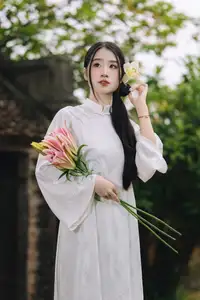 Discover the Grace of a Vietnamese Woman in White Ao Dai with Elegant Lilies - image 1