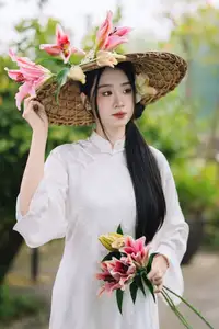 Discover the Grace of a Vietnamese Woman in White Ao Dai with Elegant Lilies - image 3