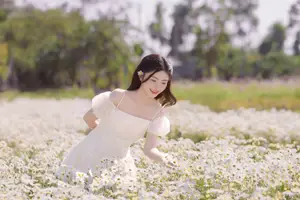 Serene Beauty: Young Woman in White Flower Field, Embracing Tranquility Under Gentle Sunlight - image 10